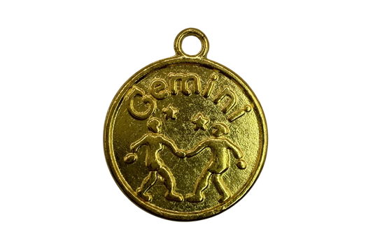 Gold round Gemini zodiac coin medallion with twin figures and star details