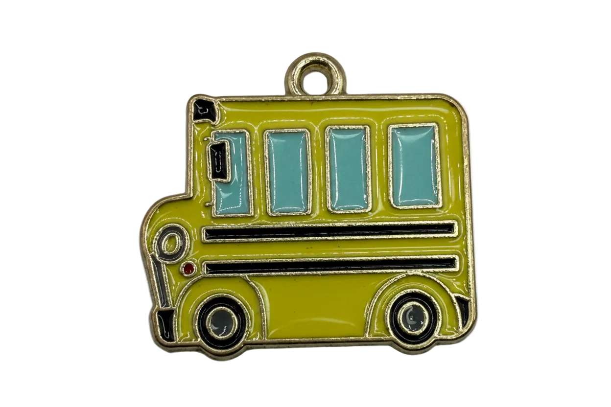 Yellow enamel school bus charm with blue windows and gold outline
