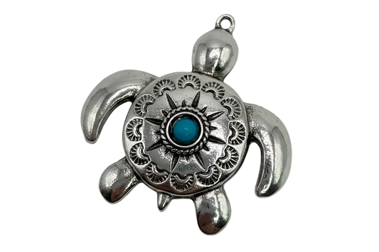 Polished silver-tone engraved sea turtle with sunburst detail and turquoise center gem