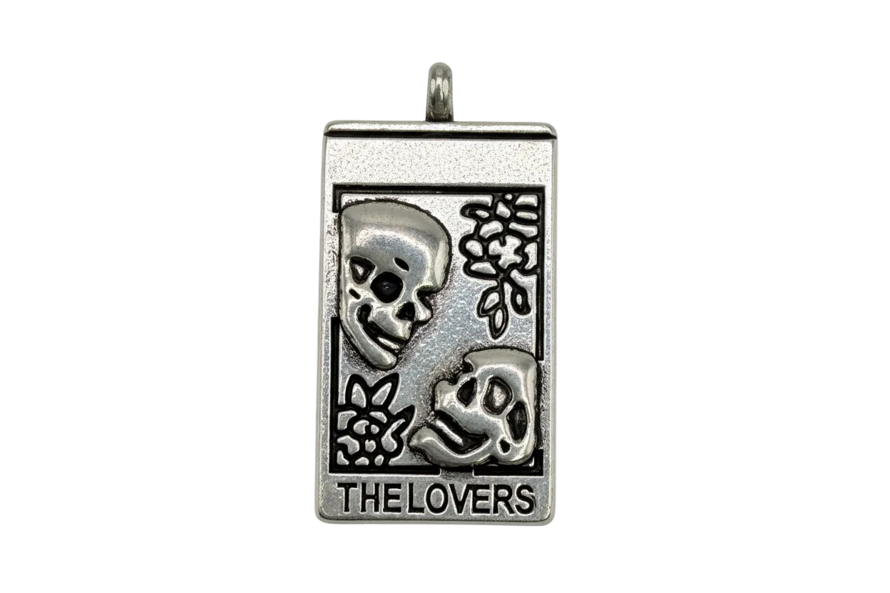 Antiqued silver tarot card pendant with two skull faces and text “THE LOVERS”