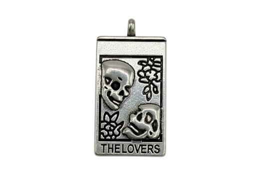 Antiqued silver tarot card pendant with two skull faces and text “THE LOVERS”