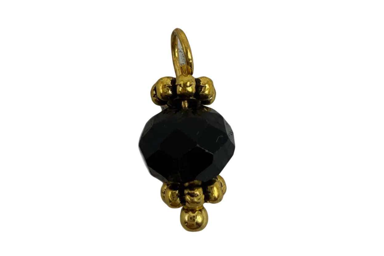 Faceted black round gem with polished gold bead accents