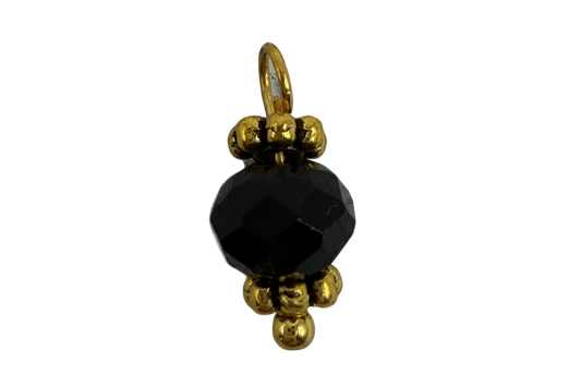 Faceted black round gem with polished gold bead accents