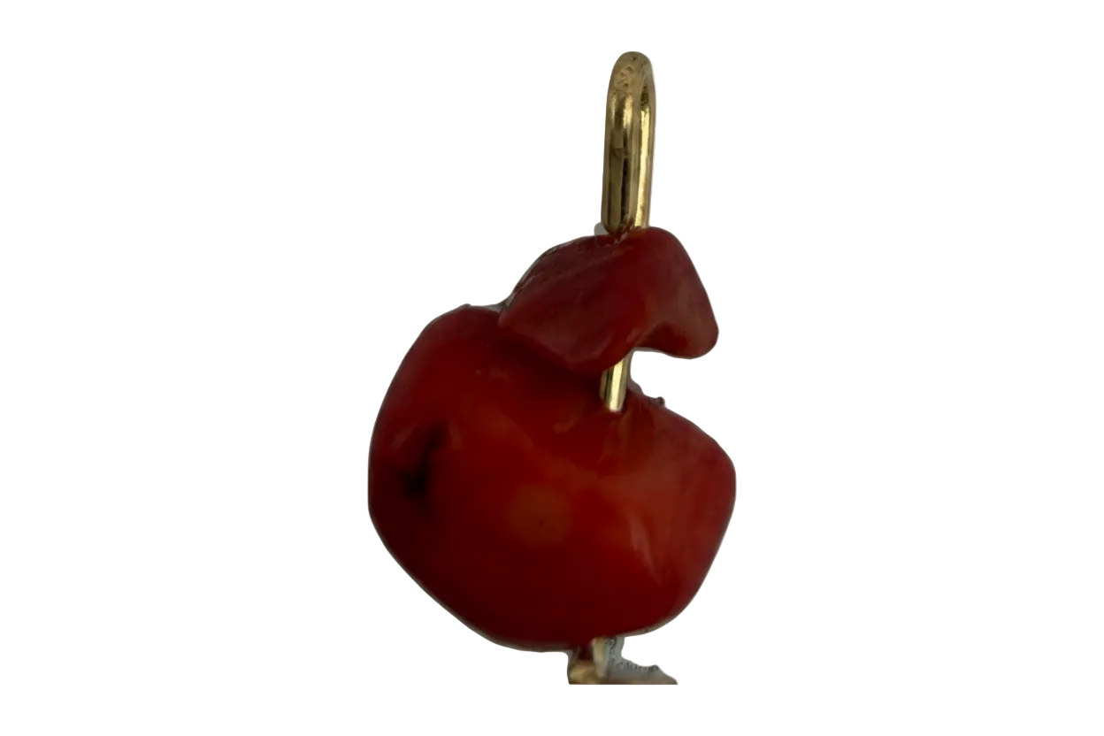 Glossy red organic sculptural charm with polished gold accent on black background