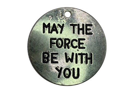 Round antiqued silver-tone coin with blackened engraved message lettering