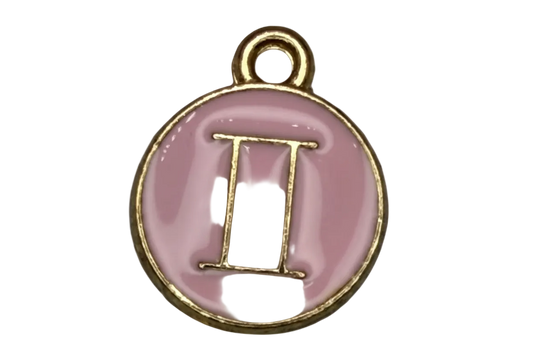 Pink enamel Gemini symbol medallion in gold with a small clear gem accent