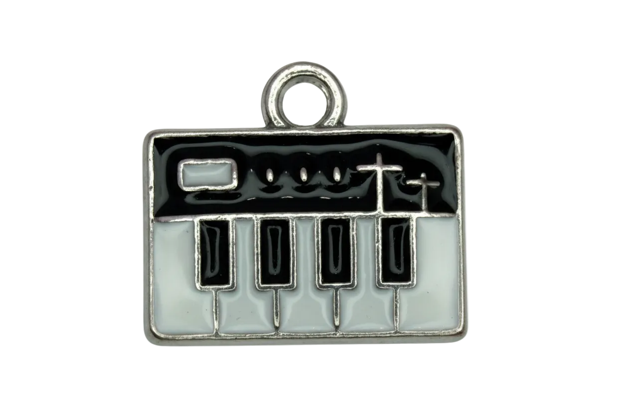 Silver-tone enamel plaque with black and white piano keys and birds on a wire design