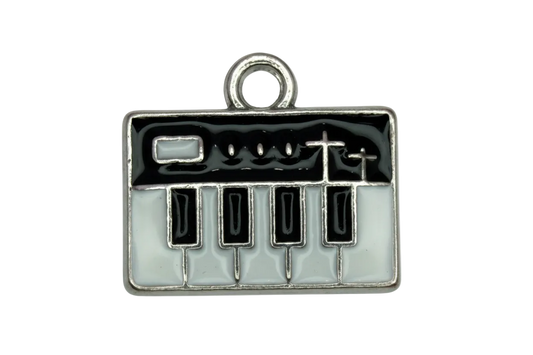 Silver-tone enamel plaque with black and white piano keys and birds on a wire design