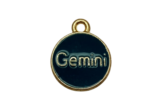 Dark teal enamel round disc with raised gold Gemini lettering and gold rim