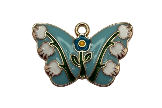 Sky-blue enamel butterfly with white flowers, green stems, and gold outline