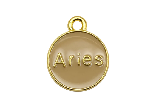 Round tan enamel Aries zodiac medallion with raised gold lettering and polished gold rim