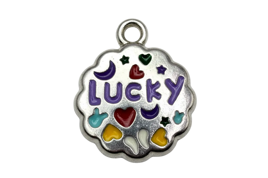 Scalloped silver-tone enamel medallion with purple LUCKY lettering, hearts, moons, and stars