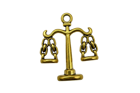 Gold balance scale with two hanging pans and subtle antique-style shading on a black background
