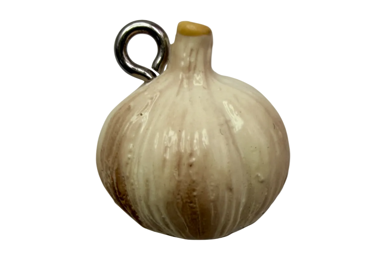 Glossy ivory garlic bulb charm with subtle golden shading on a black background