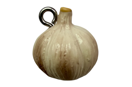Glossy ivory garlic bulb charm with subtle golden shading on a black background