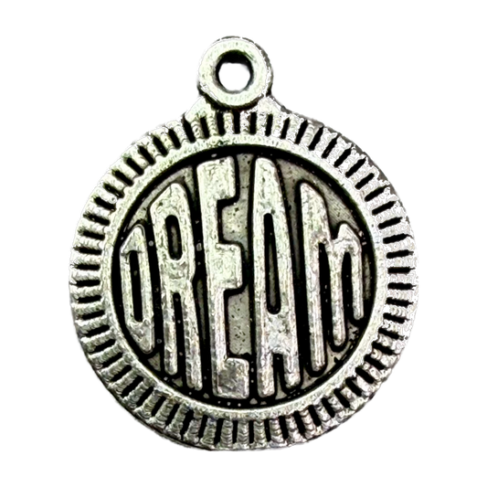 Antiqued silver round coin with raised DREAM lettering and ridged border