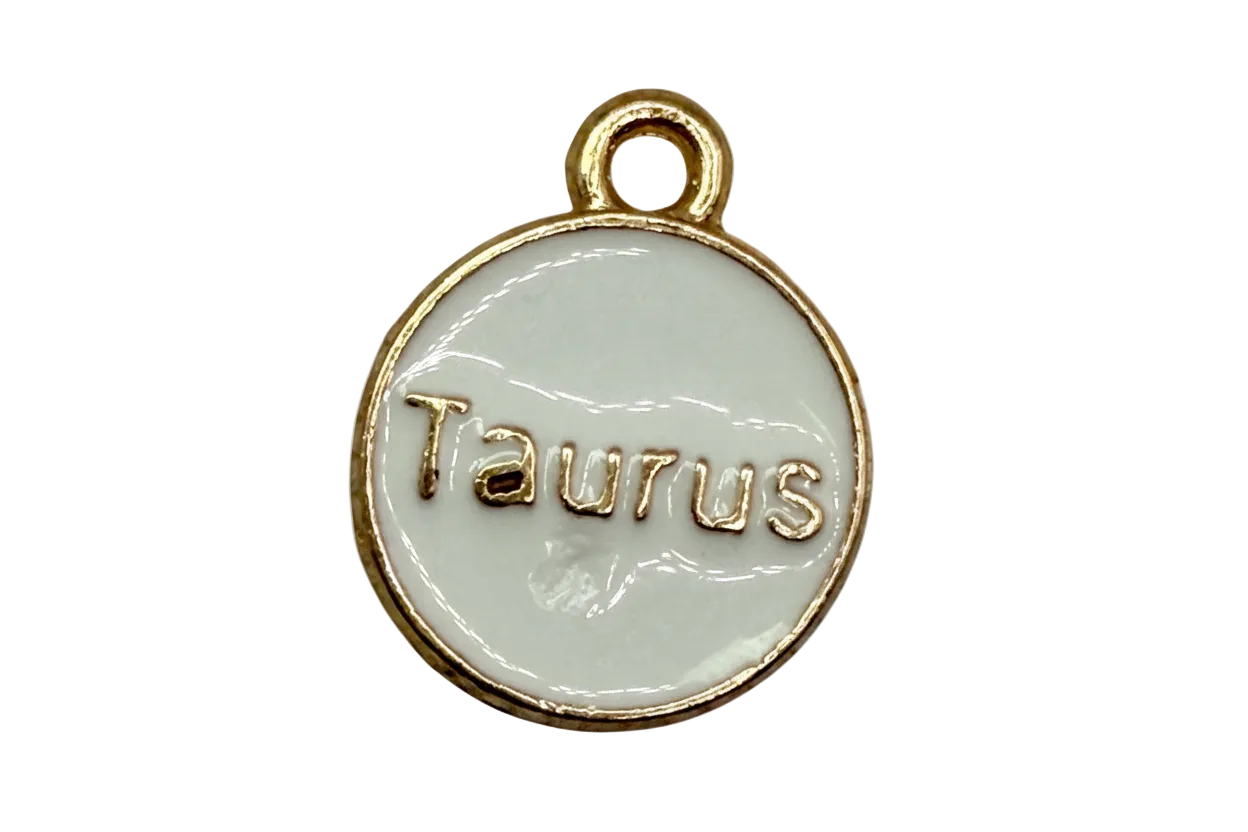 White enamel round disc with raised gold Taurus lettering and gold border
