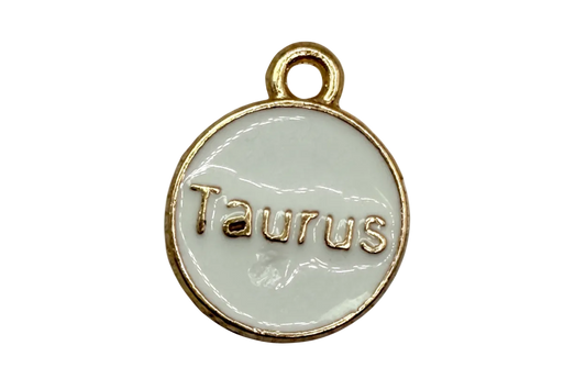 White enamel round disc with raised gold Taurus lettering and gold border