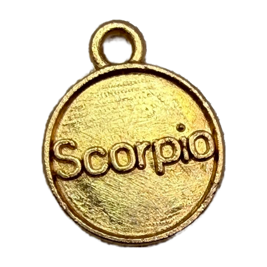 Gold round coin charm with raised Scorpio lettering and brushed finish