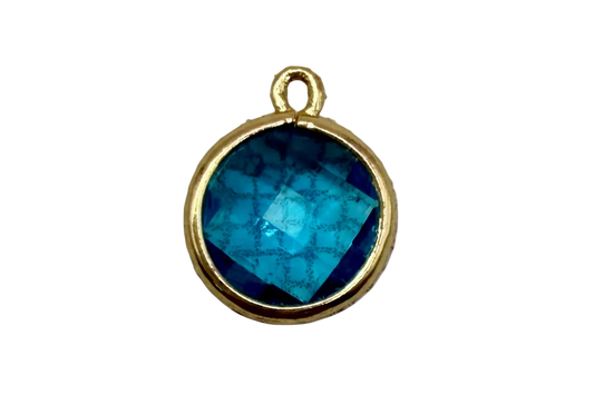 Round faceted ocean-blue gem in a polished gold frame