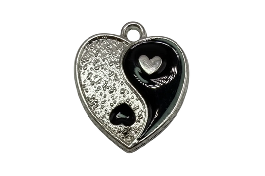 Two-tone yin-yang heart charm in silver and glossy black enamel with small heart details
