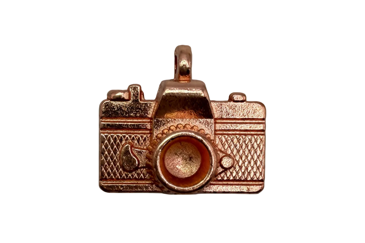 Rose-gold toned vintage camera charm with textured body and raised lens detail
