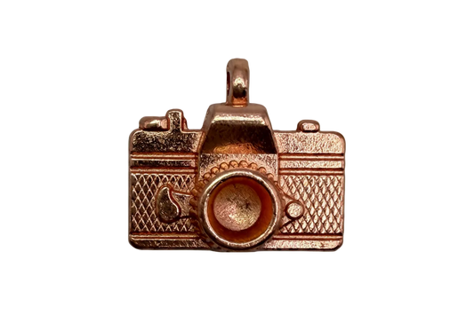 Rose-gold toned vintage camera charm with textured body and raised lens detail