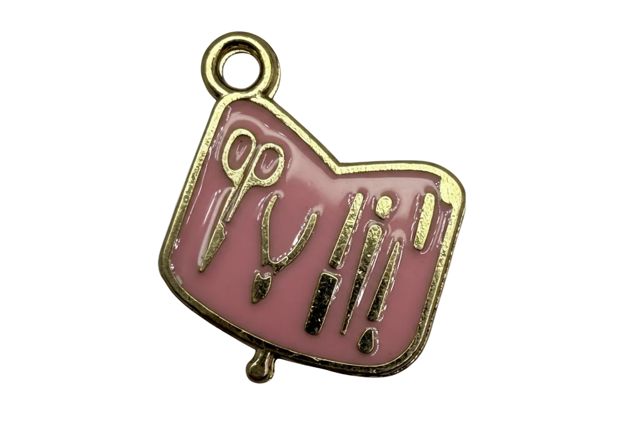 Blush pink enamel plaque with gold outlines of scissors and beauty tools