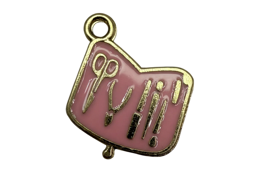 Blush pink enamel plaque with gold outlines of scissors and beauty tools