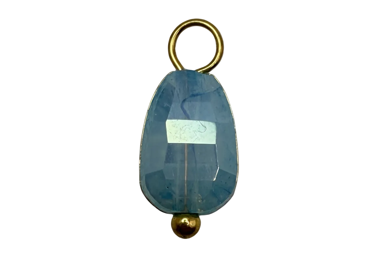 Faceted sky blue oval crystal gem with gold accents on black background