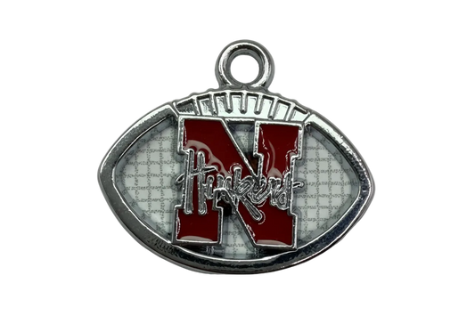 Silver football emblem with glossy red varsity letter N and white textured background