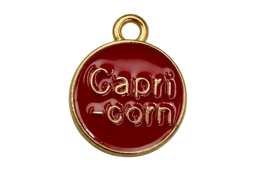 Round red enamel Capricorn coin with raised gold lettering and gold edge