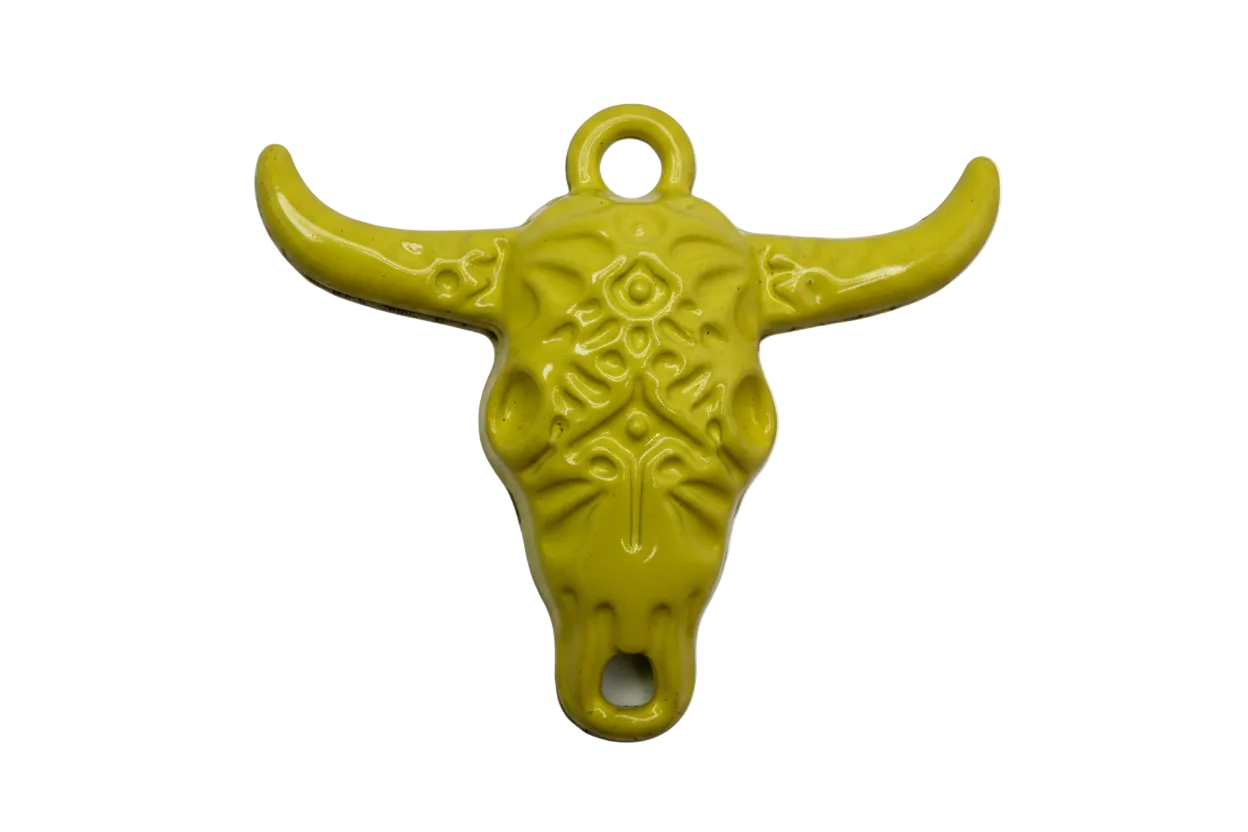 Glossy yellow steer skull charm with ornate filigree detailing and curved horns, silver-toned base