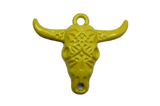 Glossy yellow steer skull charm with ornate filigree detailing and curved horns, silver-toned base