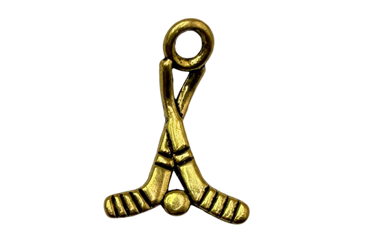 Gold crossed hockey sticks with puck charm, antiqued finish and engraved details