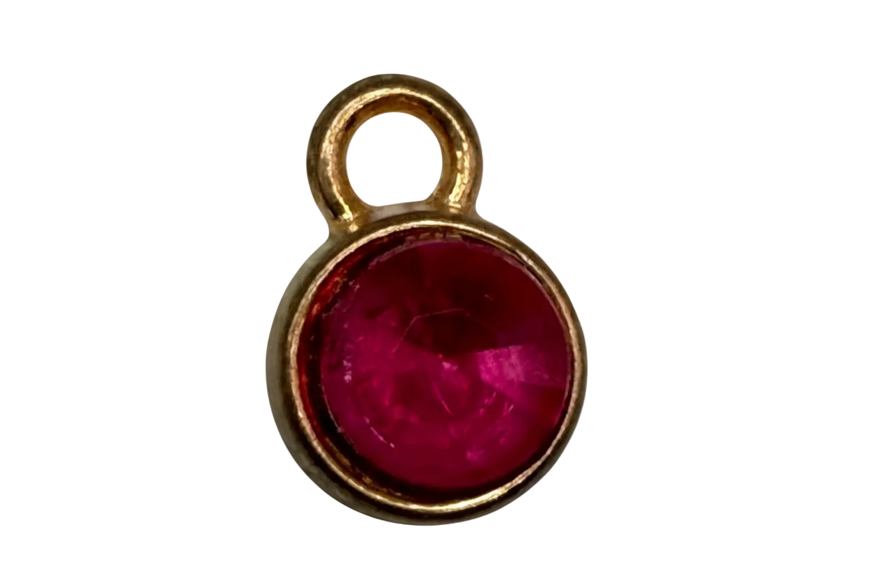 Gold round charm with faceted raspberry pink gem in a smooth circular frame