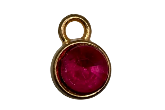 Gold round charm with faceted raspberry pink gem in a smooth circular frame
