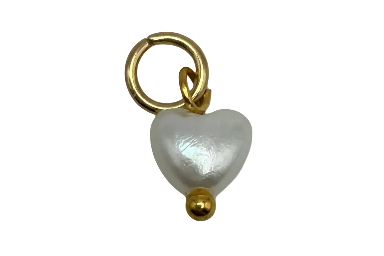 Lustrous white pearl heart charm with gold accents on black background
