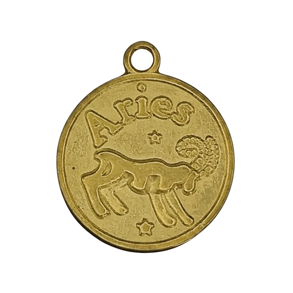 close-up of a round gold-tone Aries ram zodiac charm with stars on a black background