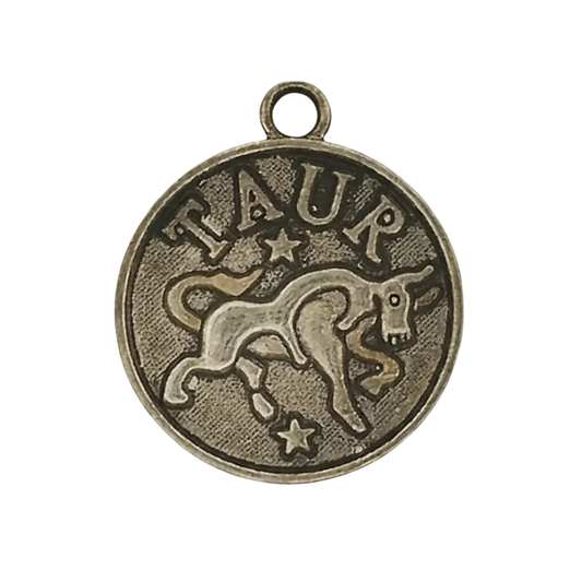 close-up of round bronze Taurus coin charm with bull and stars