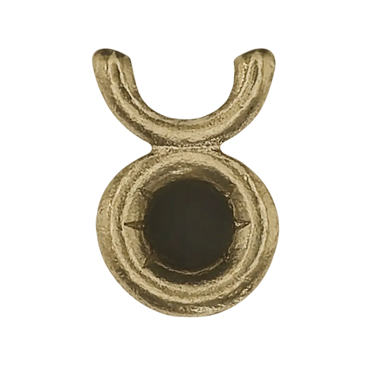 close-up of a small gold-tone Taurus symbol charm on a black background