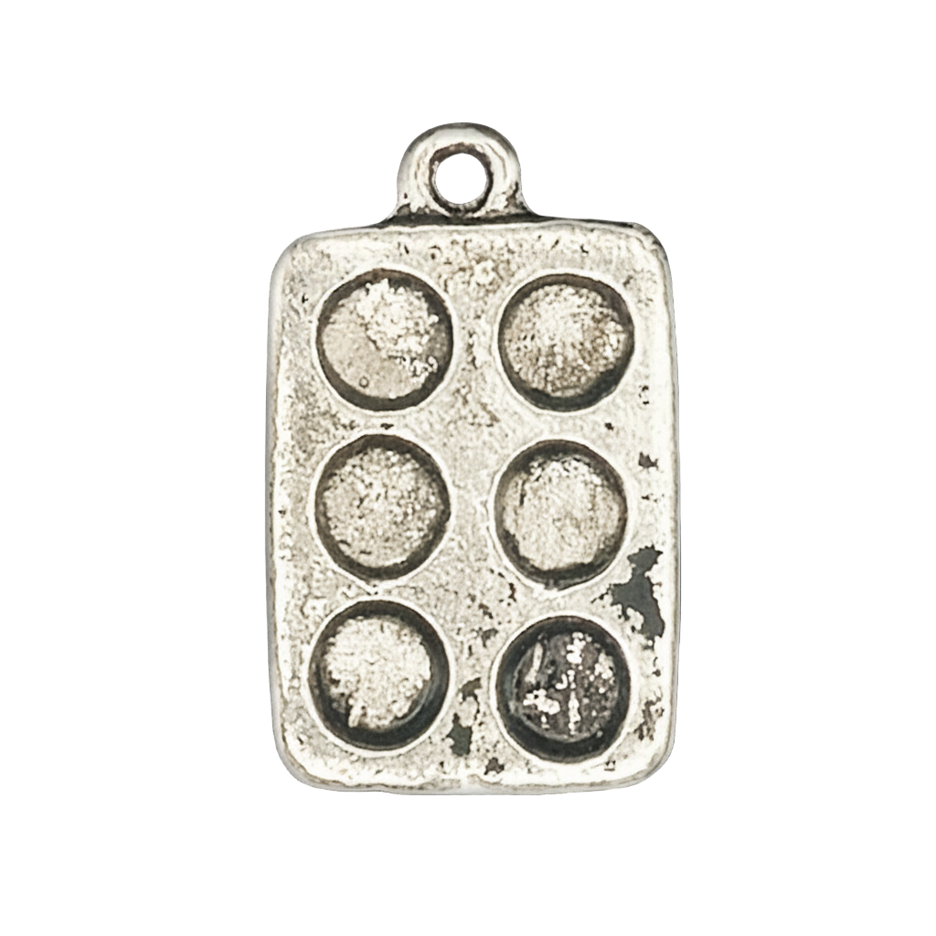 Close-up of a silver muffin pan charm with six round wells on a black background.