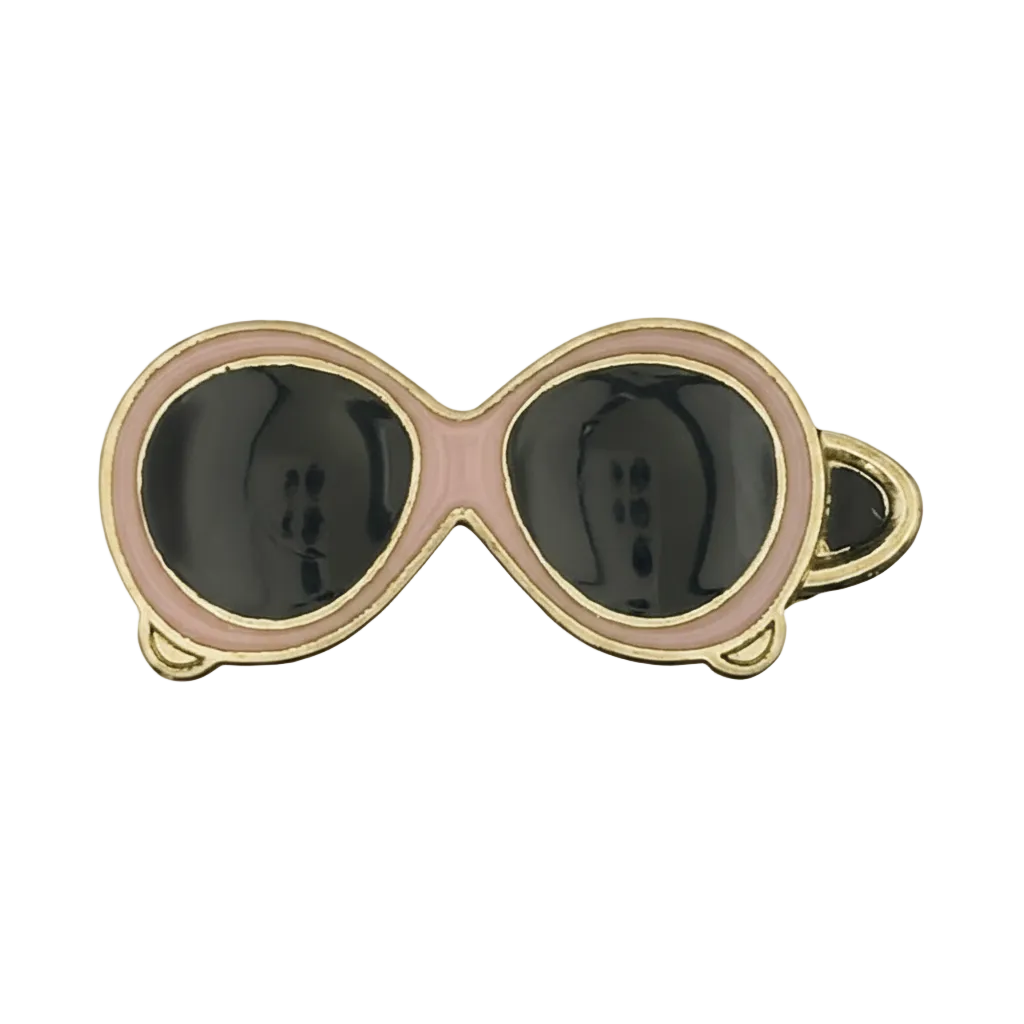 close-up of pink and black sunglasses charm with gold edging on black background
