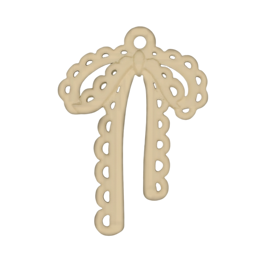 close-up of a gold-tone scalloped bow charm on a black background
