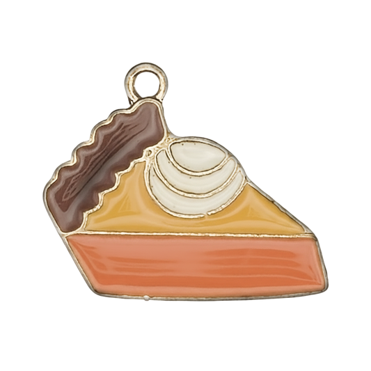 Close-up of enamel pie slice charm with whipped cream, orange filling, and brown crust.