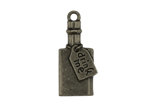 close-up of a small antique-silver bottle charm with a tag that says 'drink me'