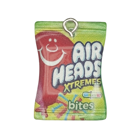 close-up of a miniature Airheads Xtremes Bites candy bag charm on a black background