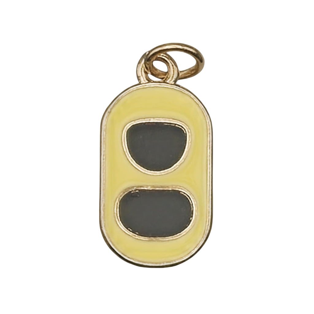 Close-up of yellow enamel soda can pull tab charm with gold-tone edges on a black background.