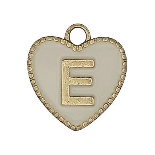 close-up of heart-shaped charm with gold letter E on white