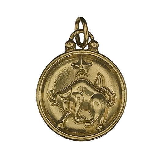 close-up of round gold charm with embossed bull and star